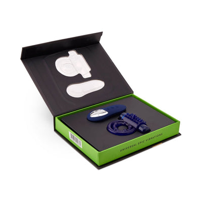 Open box packaging showing a blue remote control and textured cock ring with a green interior tray.