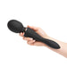 Hand holding a black Sensuelle Xlr8 Alluvion dual-ended wand vibrator with ergonomic design and control buttons.