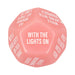 Pink 12-sided adult game dice with white text featuring playful intimate prompts for couples.