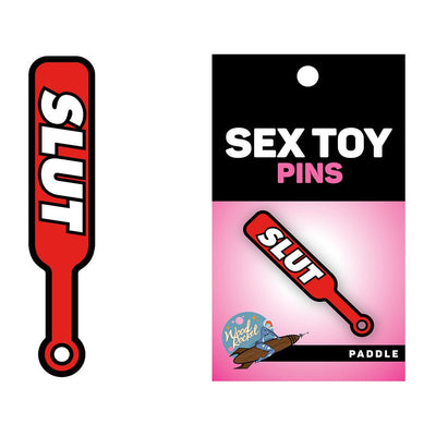 Red enamel lapel pin shaped like a paddle with the word "SLUT" in bold white letters, displayed on branded packaging.