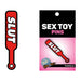 Red enamel lapel pin shaped like a paddle with the word "SLUT" in bold white letters, displayed on branded packaging.