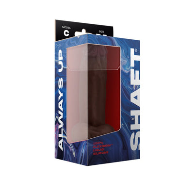 Shaft Model C liquid silicone dildo with balls in dark color, displayed in blue marbled packaging with clear window.