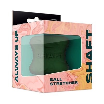 Shaft Model H gray silicone ball stretcher displayed in peach and teal packaging with clear window.