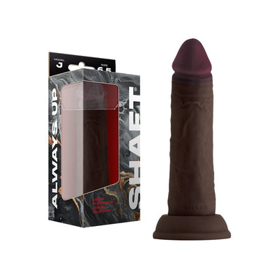 Shaft Model J 6.5 inch liquid silicone dildo in dark brown with suction cup base and packaging box.