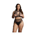 Plus size model wearing black netted two-piece bra set with keyhole detail and high-waisted bottoms against white background.