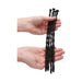 Hands holding four black silicone spiral urethral sounding plugs of varying thicknesses.