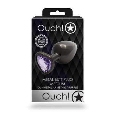 Ouch! medium gunmetal metal butt plug with heart-shaped amethyst purple jewel on base in black packaging.