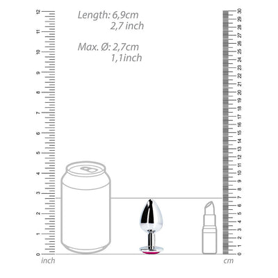 Small silver metal butt plug with pink heart-shaped gem base shown next to soda can and lipstick for size comparison.