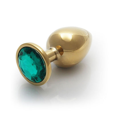 Large gold-toned metal butt plug with a round teal gem base, smooth and tapered for comfortable use.