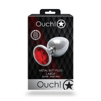 Packaging of Shots Ouch! large silver metal butt plug with a ruby red jewel base on a black and red background.