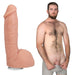 Realistic 8.5-inch lifelike dildo with textured veins and suction base next to a shirtless man in gray shorts.