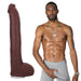 Dark brown realistic 11-inch dildo with textured veins and testicles next to a shirtless man in gray shorts.