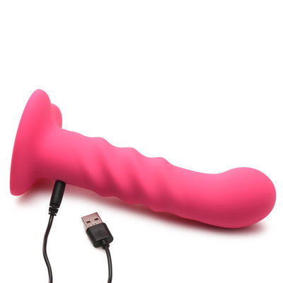 Pink ribbed silicone dildo with heart-shaped suction base and USB charging cable on white background.