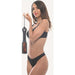 Woman in black lingerie holding a tortoiseshell patterned spanker paddle with a black handle and wrist leash.