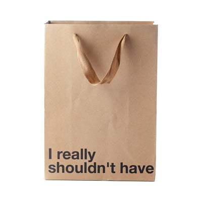 Kraft paper gift bag with brown ribbon handles and bold black text reading I really shouldn't have on front.