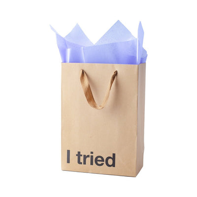 Kraft paper gift bag with brown ribbon handles and "I tried" text, filled with light purple tissue paper.