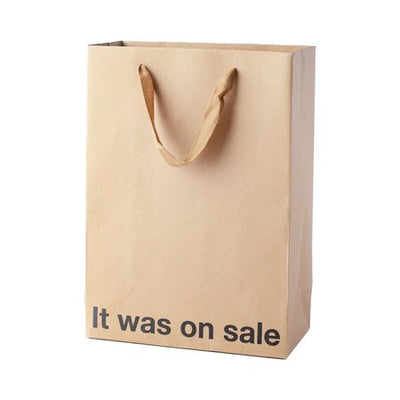 Kraft paper gift bag with brown ribbon handles and "It was on sale" printed in black text.