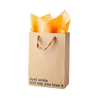 Kraft gift bag with brown ribbon handles and orange tissue paper, printed with "Just smile and say you love it" text.