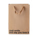 Kraft paper gift bag with brown ribbon handles and black text reading Just smile and say you love it.