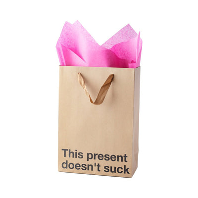 Kraft gift bag with brown ribbon handles and pink tissue paper, printed with playful text "This present doesn't suck"