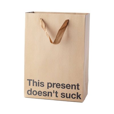 Kraft paper gift bag with brown ribbon handles and bold black text reading This present doesn't suck.