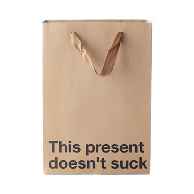 Kraft paper gift bag with brown ribbon handles and bold black text reading This present doesn't suck.