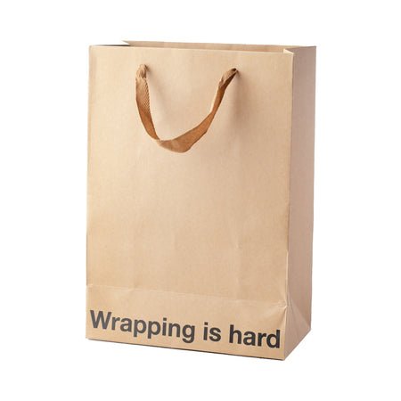 Kraft gift bag with brown ribbon handles and "Wrapping is hard" printed on the front, 11 x 8 x 4 inches.