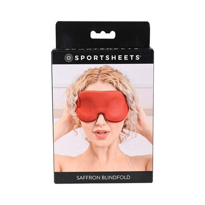 Packaging of Sportsheets Saffron Blindfold featuring a woman wearing the memory foam blindfold in a rich saffron color.