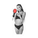 Woman in black lingerie holding and presenting a red and black dual-sided Amor paddle with faux fur and leather sides.