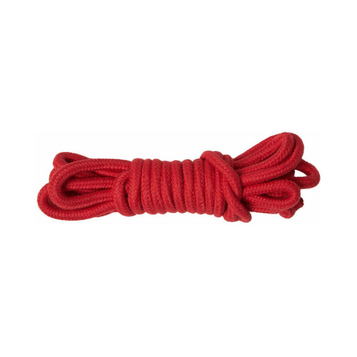 Red cotton rope neatly coiled, designed for comfortable and versatile restraint use.