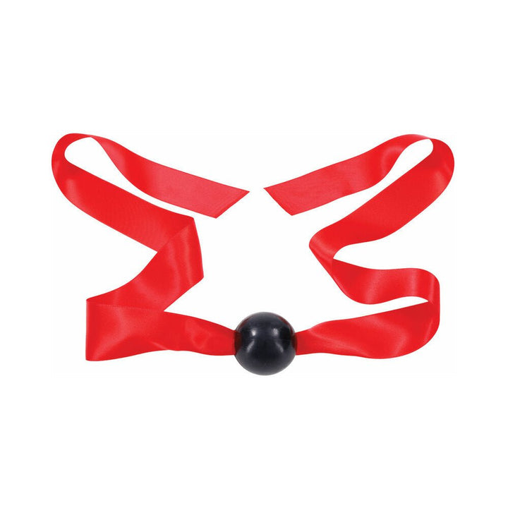 Black ball gag with long red satin ribbon straps laid flat on white background.