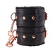 Black faux leather wrist restraints with plush lining and rose gold hardware, linked by a detachable chain clasp.