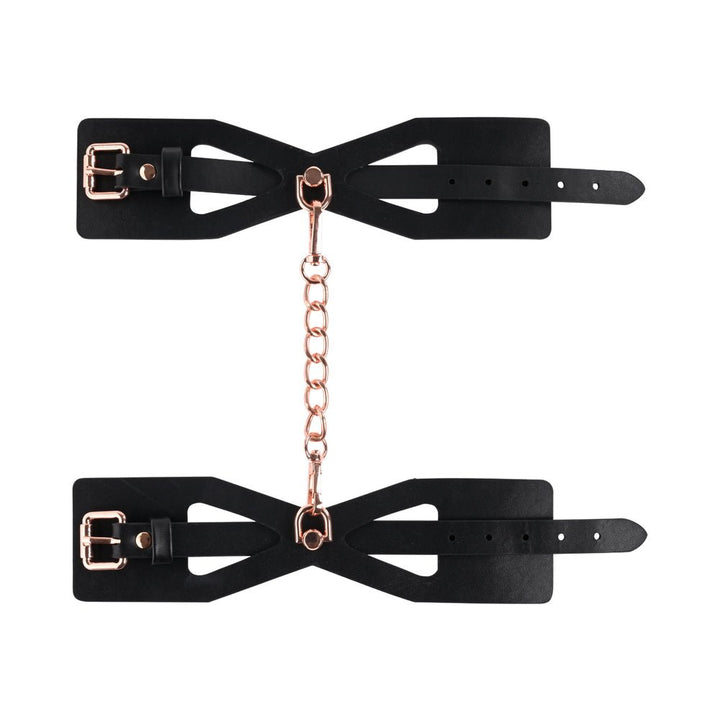 Black faux leather brat handcuffs with corset-style cutouts and rose gold chain and buckles.
