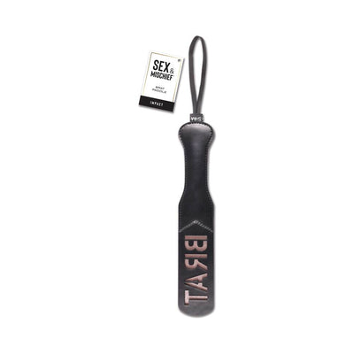 Black faux leather paddle with "BRAT" embossed, wrist loop, and Sex & Mischief branded tag attached.