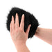 Hands wearing a black faux fur sensory mitt designed for contrasting soft and spiked tactile sensations.