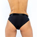 Back view of a person wearing a sleek black EmEx Silhouette harness with a smooth waistband and high-cut leg openings.