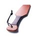 Leather wrapped wooden spanking paddle with wrist strap, polished finish and ergonomic handle for grip.