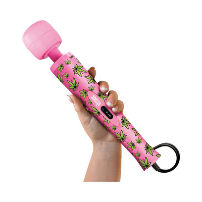Hand holding a pink wand massager with green weed leaf pattern and a black power cord attached.