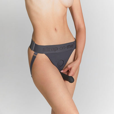 Close-up of a model wearing grey Strap-on-me harness lingerie with adjustable waistband and rings for attachments.