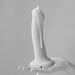 Hand holding a vanilla-colored semi-realistic silicone dildo with liquid dripping down its side.