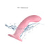 Pink curved Strap-on-me Tapping Dildo Wave with suction base shown with water splash, highlighting its waterproof feature.