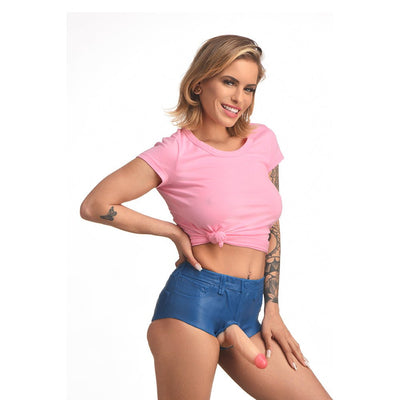 Woman wearing skin-tight blue silicone booty shorts with a realistic dildo attachment and a pink knotted crop top.