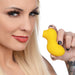 Woman holding a yellow duck-shaped clitoral stimulator with a suction tip against a white background.