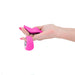Hand holding pink Sugar Pop Leila panty vibrator and matching remote control on white background