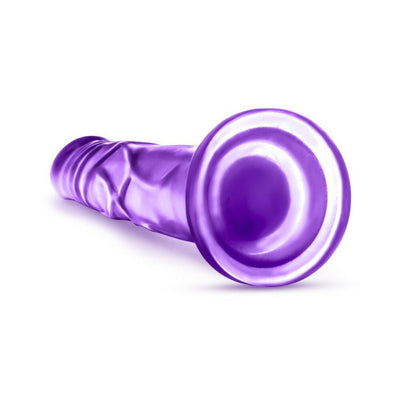 Purple realistic dildo with suction cup base lying on white background.