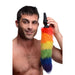 Man holding a black silicone butt plug with a long, fluffy rainbow-colored faux fur tail against a white background.