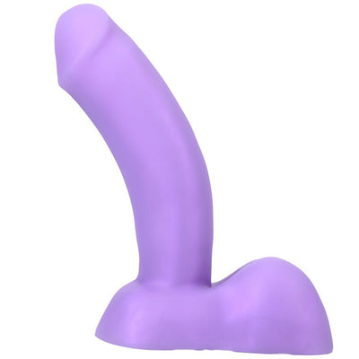 Purple curved silicone dildo with realistic base and testicles, designed for harness compatibility and targeted stimulation.