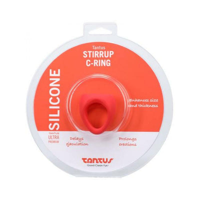 Tantus Stirrup C-ring in red silicone displayed in round clear and orange packaging with product benefits and branding visible.