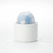 Compact Tenga Iroha Temari Mizu in white holder with blue wave design, shown with water droplets on a white surface.