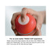 Hand holding a red Tenga Rolling Head Cup showing the air hole with a finger covering it for vacuum control.